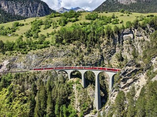 Landwasserviaduct in de bergen van Davos bij Filisur. Mooie oude stenen brug met een rijdende trein. lentetijd