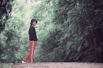 Obraz premium Thai woman leisure posed in the green forest in the morning.