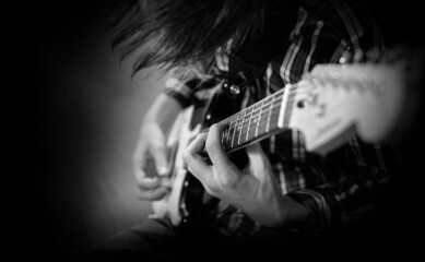 A young man plays the electric guitar