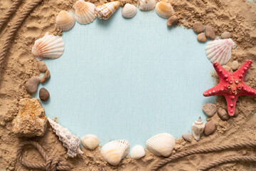 Marine themed frame for text. Blue background with seashells and red starfish on the sand with copy space for ad.