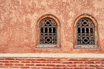 Fototapeta na wymiar The wall of building with two vintage windows.