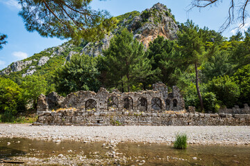 Olympos ancient ruin site view in popular resort town of Olympos, near Antalya, Turkey.  Olympos archaeological site with natural landscape.