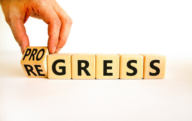 Regress or progress symbol. Businessman turns wooden cubes and changes the word Regress to...