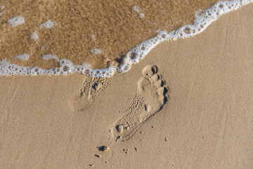 Footprints on wet sand by the sea