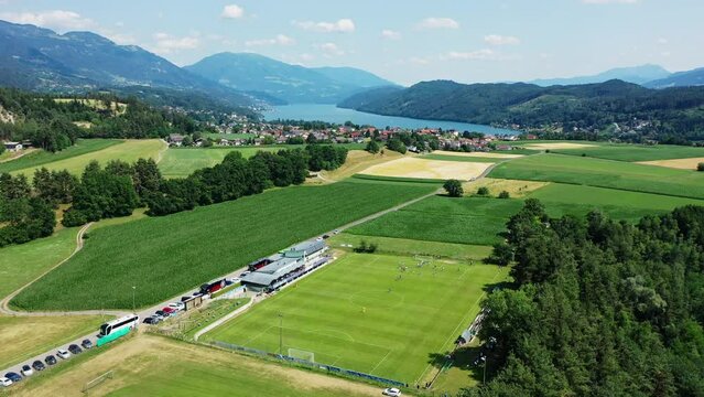 Drone view over football field near Millstatter see in Austria, in the Dolomites. Aerial video of the lake and houses near it, the calm atmosphere of the Austrian Seeboden Karntern