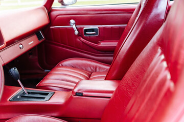 interior is made of red leather of old powerful classic American car