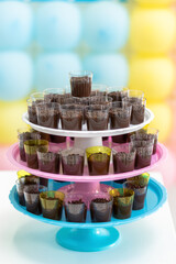 Cups of brigadeiro on triple support for party sweets.