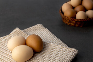 Chicken eggs in a wicker basket on the table. Eggs on a kitchen towel