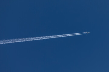 aviation, travel by airplane, bright blue sky on a sunny day without clouds, an airplane is flying...
