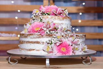 Naked Cake birthday cake decorated with delicate white and pink flowers at a female 50th birthday party