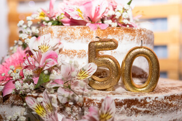 Close up festive cake with golden candles - number 50