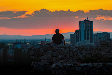 Obraz premium A Man Watching the Sunset in the City