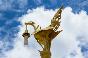 Fototapeta na wymiar Night lamp - a brass casting in the shape of a swan and a graceful and beautiful animal in Thai literature against a blue sky background.