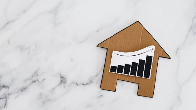 mortgages rentals and property prices increasing, house icon made of cardboard with graph showing stats going up
