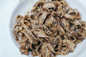 Spaghetti with truffle mushrooms and cream sauce  on wooden table in restaurant. A delicious italian fusion pasta