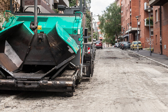 BELGRADE, SERBIA - JULY 4, 2021: Selective blur on an sphalt spreader machine, or road paver on display during a road renovation in belgrade, used to put asphalt on a street in urban environment...