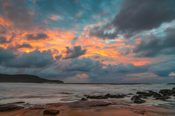 Fototapeta na wymiar Soft sunrise seascape with rocks and rain clouds