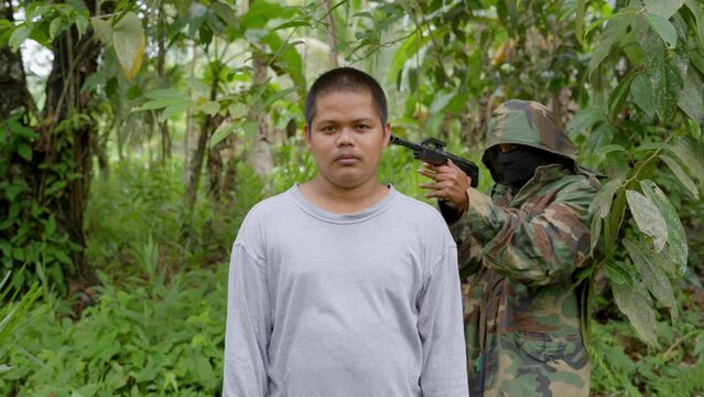 Terrorist In Military Suit Pointing A Gun On An Innocent Man In The Philippines. Static