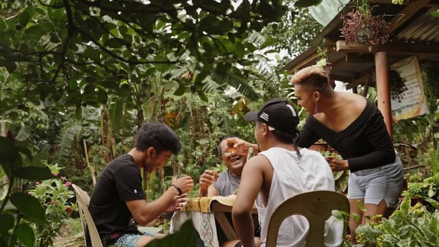 Three Men And A Gay Drinking Whisky And Chatting With Each Other Outside The House In A Rural Area In Philippines. Short Film - Medium Shot