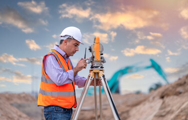 Surveyor engineer wearing safety uniform and helmet with equipment theodolite to measurement...