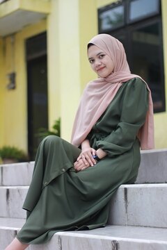 Beautiful girl sitting relaxing, Portrait of young Asian woman, wearing hijab and green clothes.