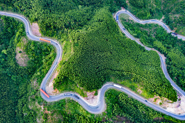 Transporting wind turbine propeller through curvy jungle road. Clean alternative energy to reduce global warming and climate change for sustainable growth.