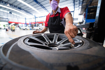 A set of workers remove the tire from the rim with a tire-removing machine device,Mechanic...