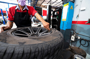 A set of workers remove the tire from the rim with a tire-removing machine device,Mechanic...