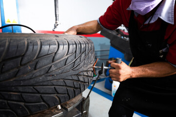 A set of workers remove the tire from the rim with a tire-removing machine device,Mechanic...