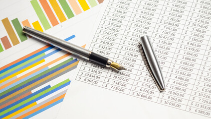 Finance analysis concept - a chart with a pen and on wooden desk