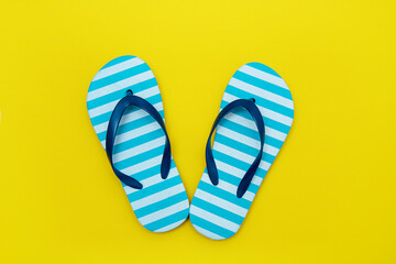 children's striped beach flip-flops on a yellow background