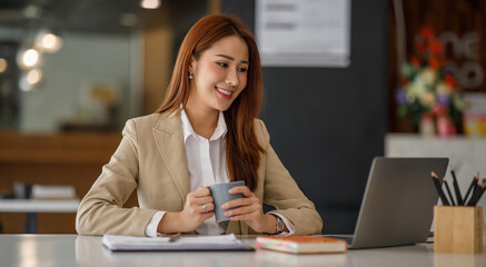 Shot of an Asian young businesswoman working on a laptop in her workstation.