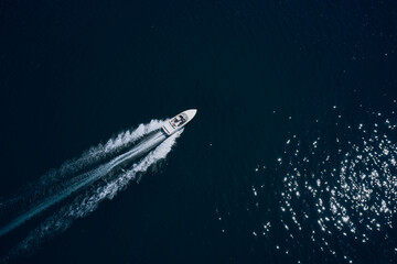 Top view of a white boat sailing to the blue sea. Drone view of a boat sailing.Motor boat in the...