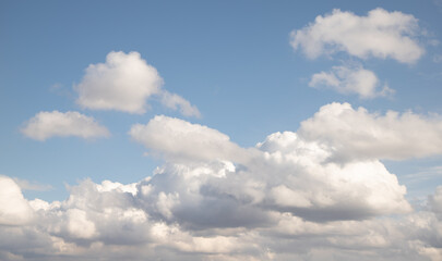 Naklejka na ściany i meble White cumulus clouds against the blue sky.