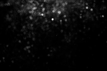 Defocused bokeh on a black background of raindrops at night