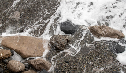 foamy coastal sea wave of a pebble beach