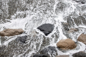 foamy coastal sea wave of a pebble beach
