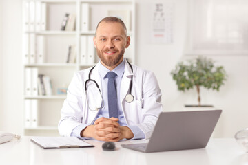 Young male doctor sitting in an office and smiling