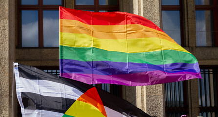 Waving rainbow flag, symbol of LGBT love during Pride Parade. Equality march in Krakow, Poland to support and celebrate LGBT+, LGBTQ gay and lesbian community.