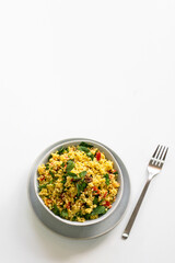 Top view of salad with bulgur, chopped parsley, tomatoes, mint, onion  on white background. Gluten free diet