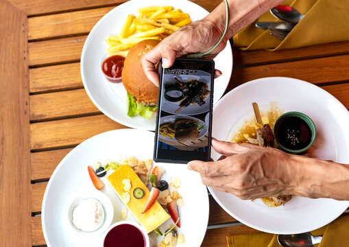 Smartphone picture which man hands takes photography by smartphone of food  grilled burgers,swwet cheese cake for ,social media concept