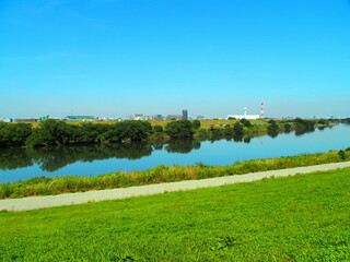 Obraz premium 土手の上から見る秋の青空を映す江戸川風景