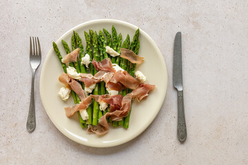 Green asparagus with mozzarella cheese and prosciutto ham. Seasonal delicious food. keto dietary lunch or dinner.
