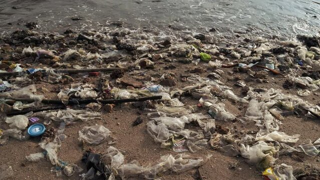 Beach pollution. Lots of Trash, plastic bottles and litter on the coastline..
