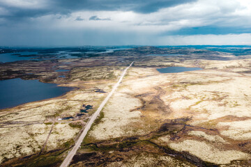 Aerial view of summer arctic landscape. Top view of the tundra. Road leading into the distance....