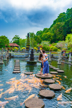Young tourist couple taking selphie on a smartphone at Water Palace of Tirta Gangga in East Bali, Indonesia