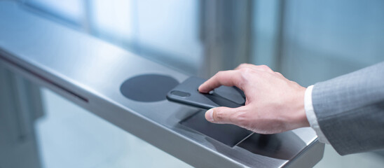 Businessman hand with business wear using smartphone to open automatic gate machine in office...