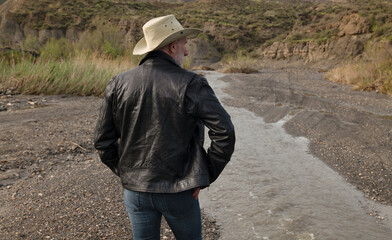 Adult man in cowboy hat in oasis of desert. Almeria, Spain