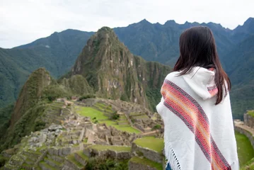 Fotobehang Machu Picchu Asian woman tourist in traditional Peruvian clothing looking at Machu Picchu, A famous tourist attraction in Cusco Region of Peru. This majestic place has known as Lost City of the Incas.