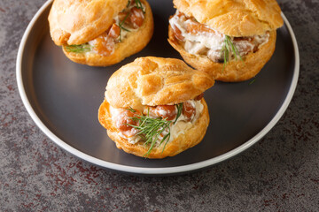 Appetizer of profiteroles stuffed with mushrooms, cream and herbs close-up in a plate on the table